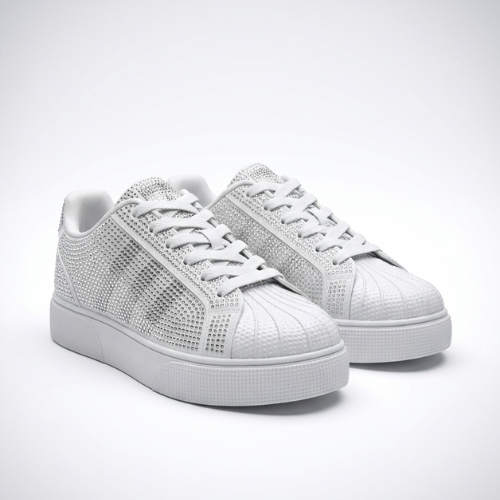 Paire de sneakers basses ornées de strass, posées sur un fond uni, vue trois-quarts avant.