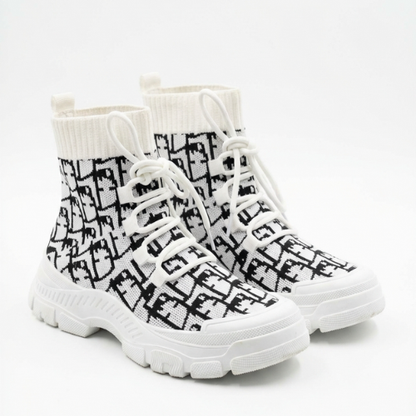 Paire de bottines chaussette à tige élastique, disposées côte à côte en angle trois-quarts sur fond neutre. 